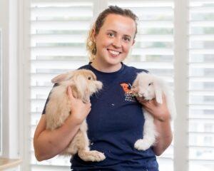 Pets and Picasso founder Anna Corwood holding two rabbits