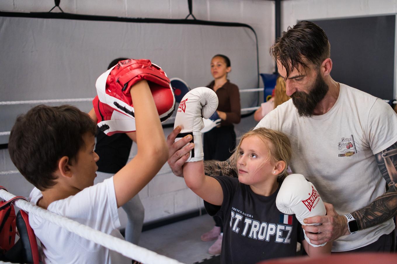 Business owner of Bang Bang Boxing in a boxing ring with children he is teaching