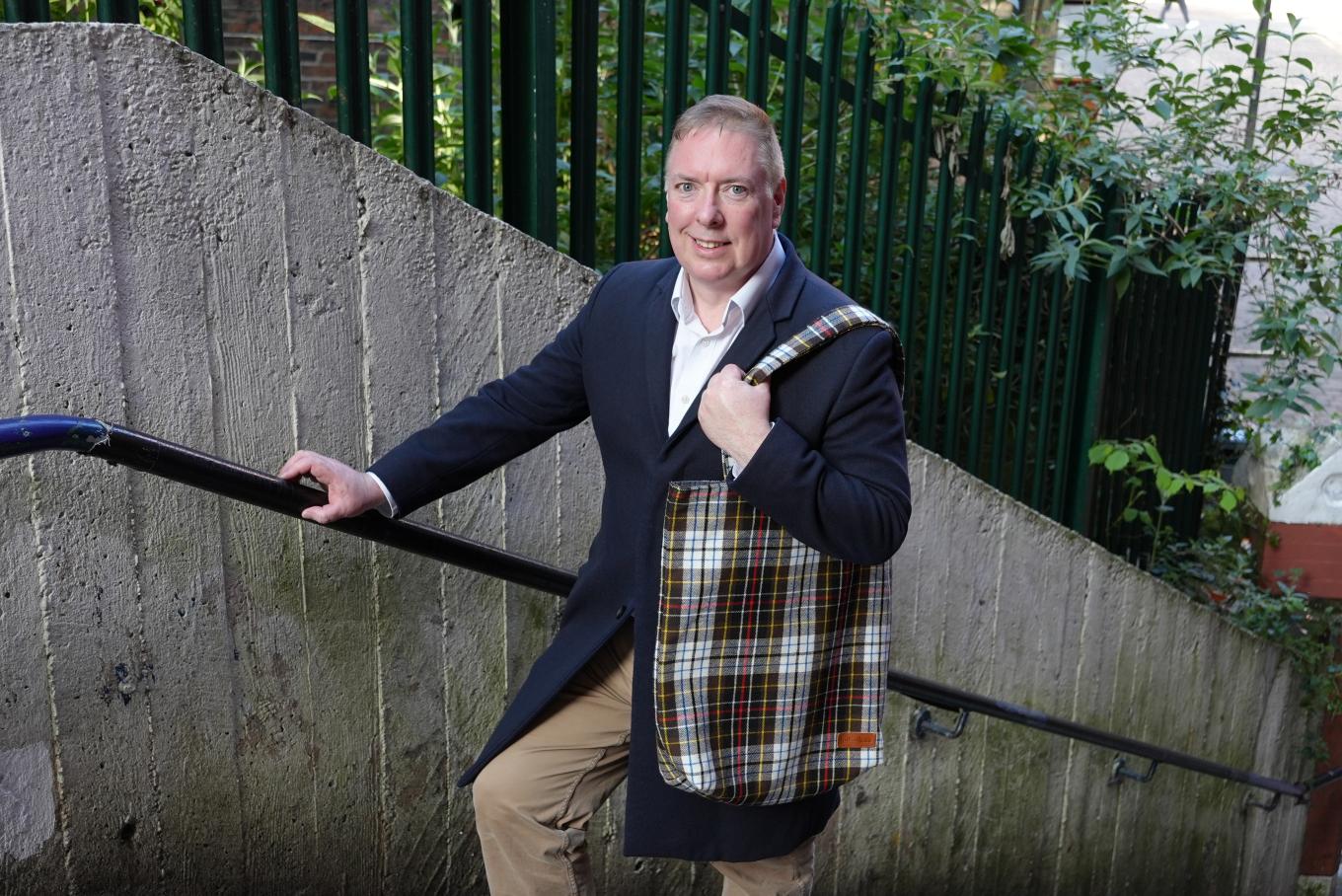 Owner of Project Harmless holding his product, a bag