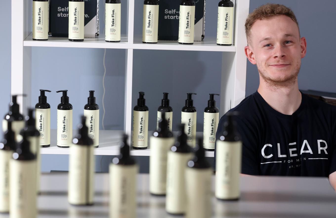 Founder of Clear for Men surrrounded by products